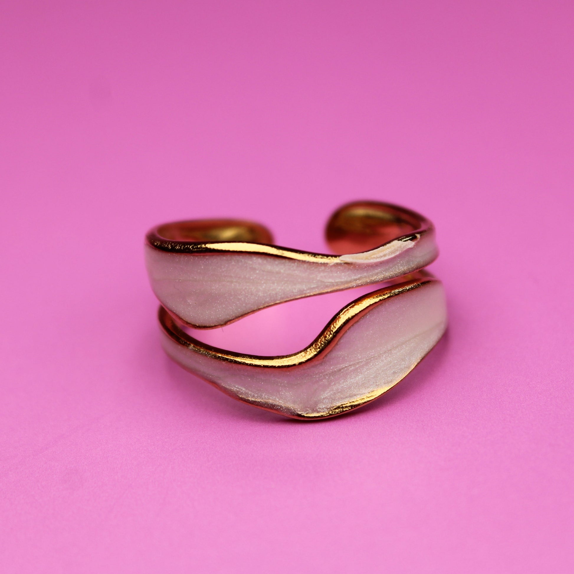Gold and silver ring on a pink background