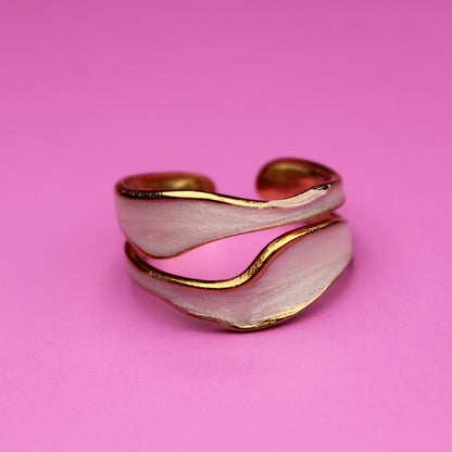 Gold and silver ring on a pink background