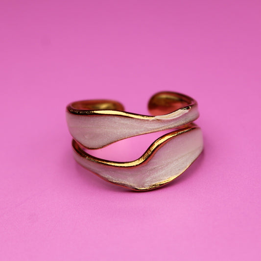 Gold and silver ring on a pink background