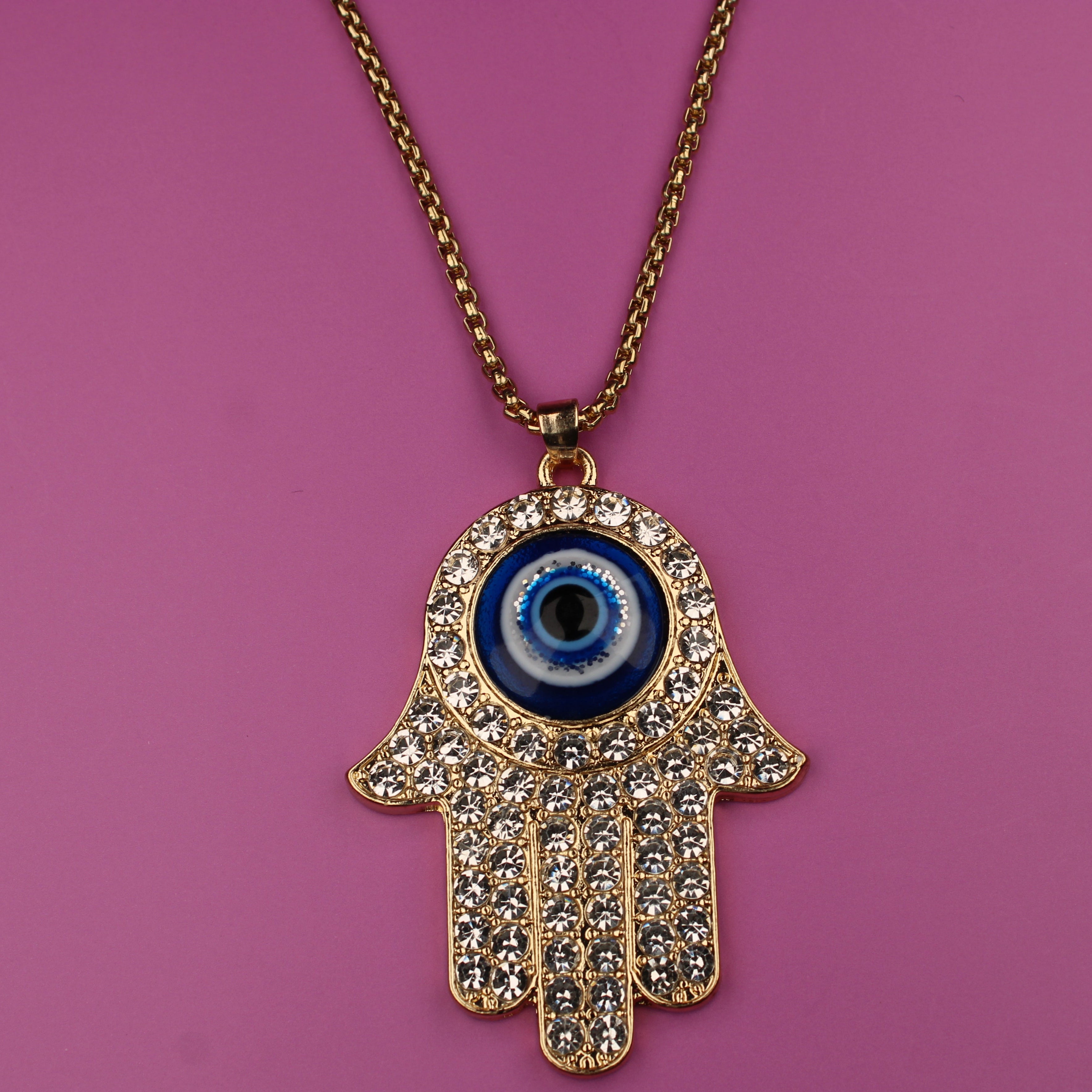 Hamsa hand necklace with a blue eye pendant on a pink background