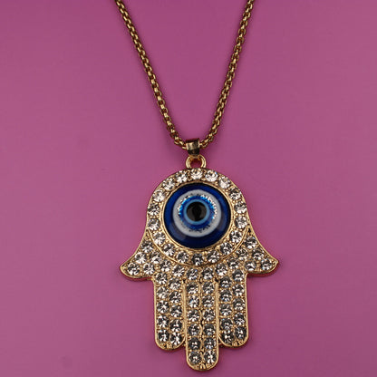 Hamsa hand necklace with a blue eye pendant on a pink background