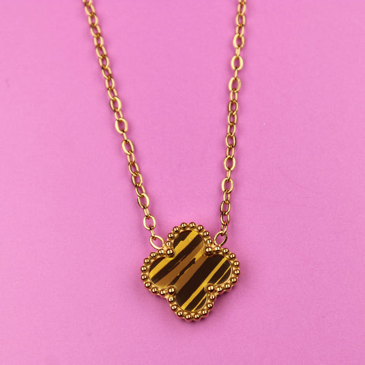Gold heart-shaped pendant necklace on a pink background