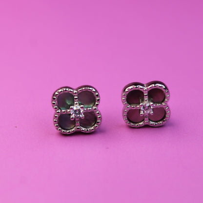 Pair of earrings with red gemstones on a pink background
