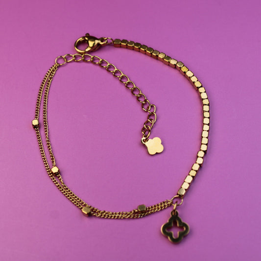 Gold bracelet with charms on a purple background