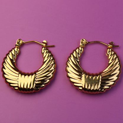 Gold hoop earrings on a purple background