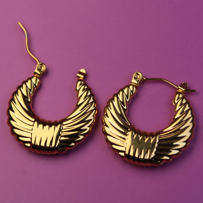 Gold hoop earrings on a purple background