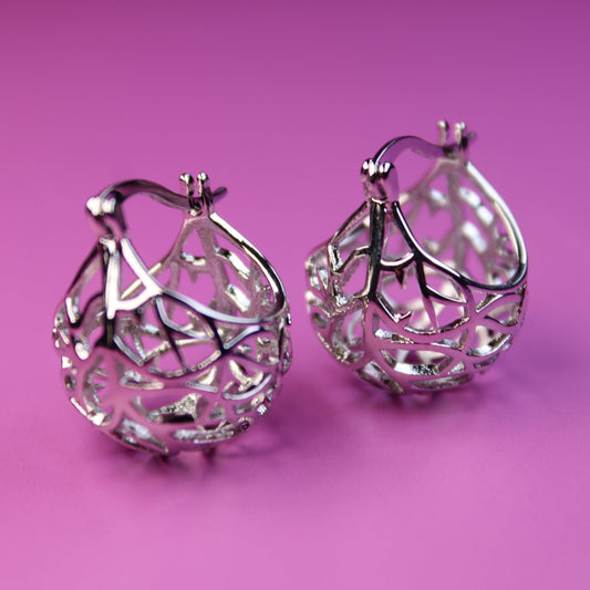 Silver hoop earrings on a pink background
