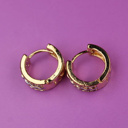 Gold hoop earrings on a purple background