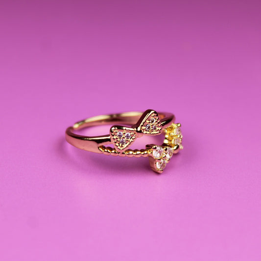 Gold ring with a yellow gemstone on a pink background