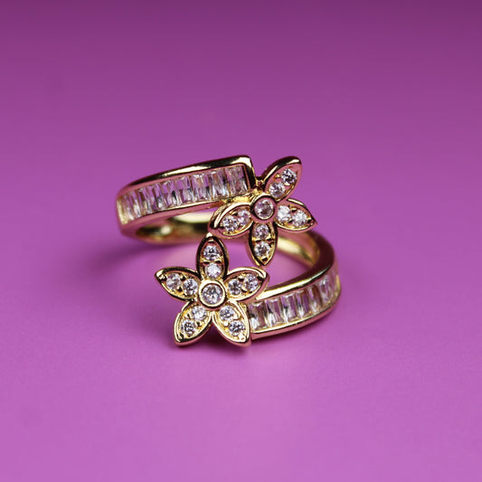 Gold ring with butterfly design on a pink background