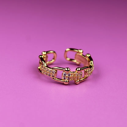 Gold ring with pink gemstones on a pink background