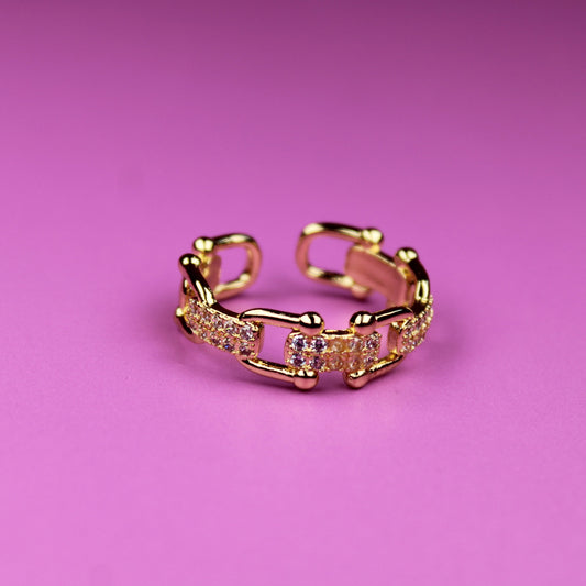 Gold ring with pink gemstones on a pink background