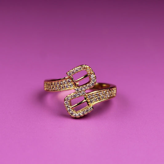 Gold ring with heart design on a pink background