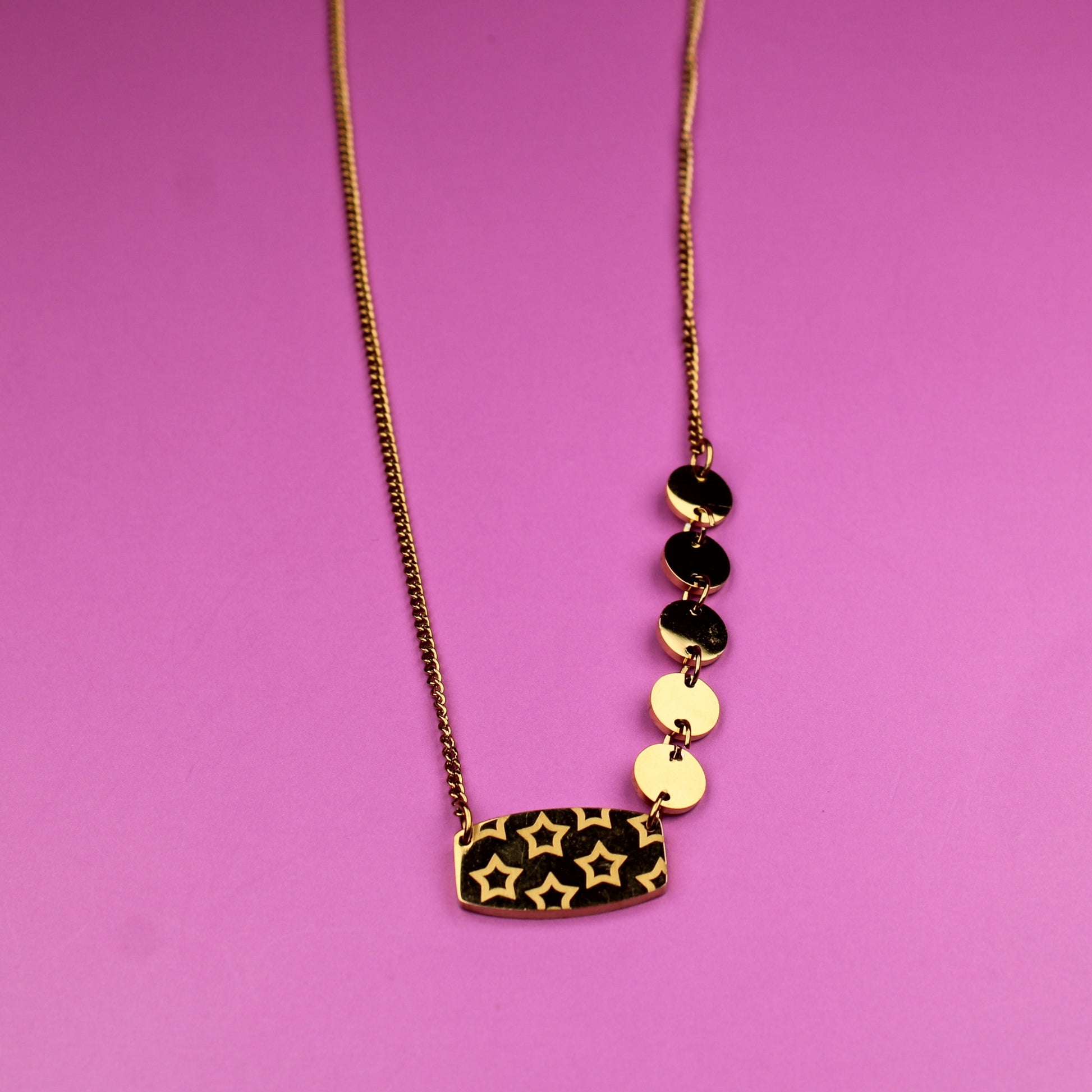 Necklace with leopard print pendant and black and gold beads on a pink background