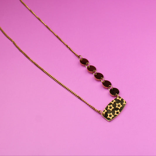 Necklace with red and green beads on a pink background
