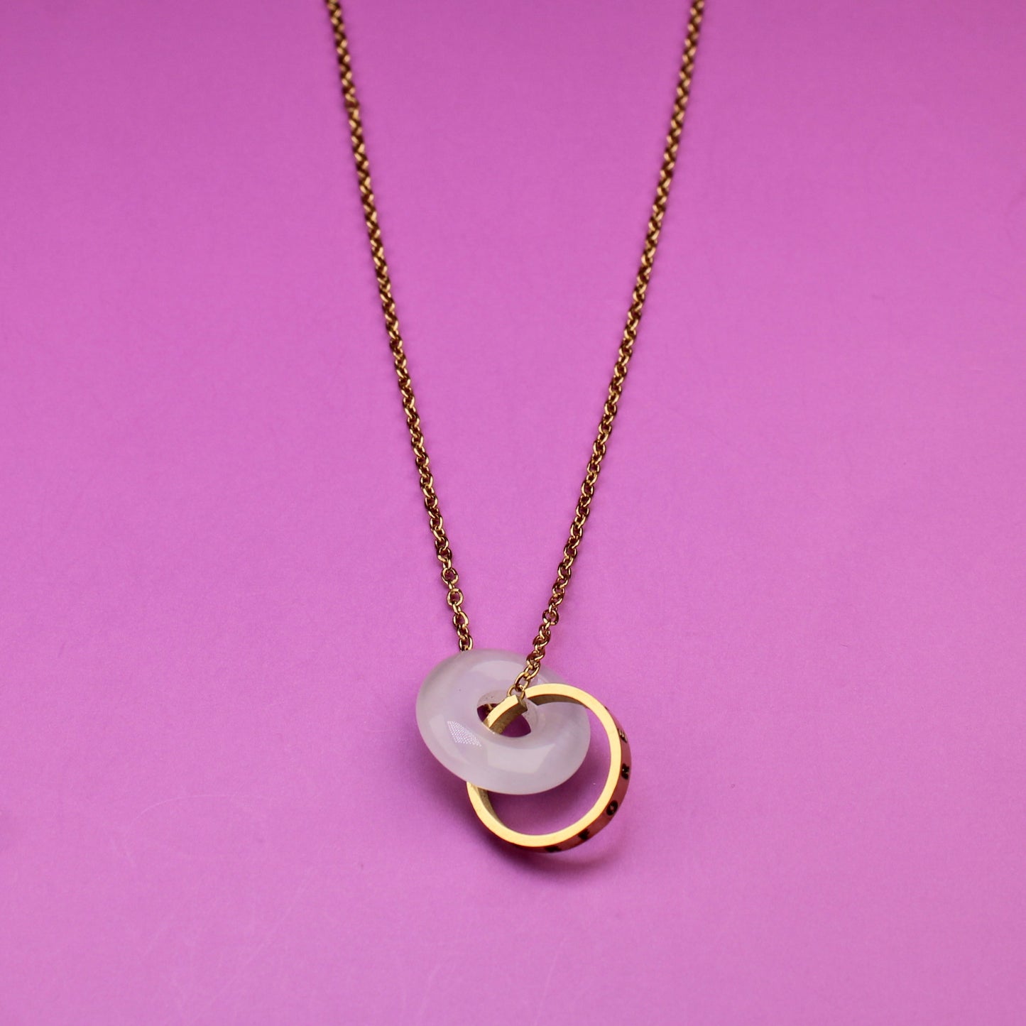 Necklace with a tag on a pink background