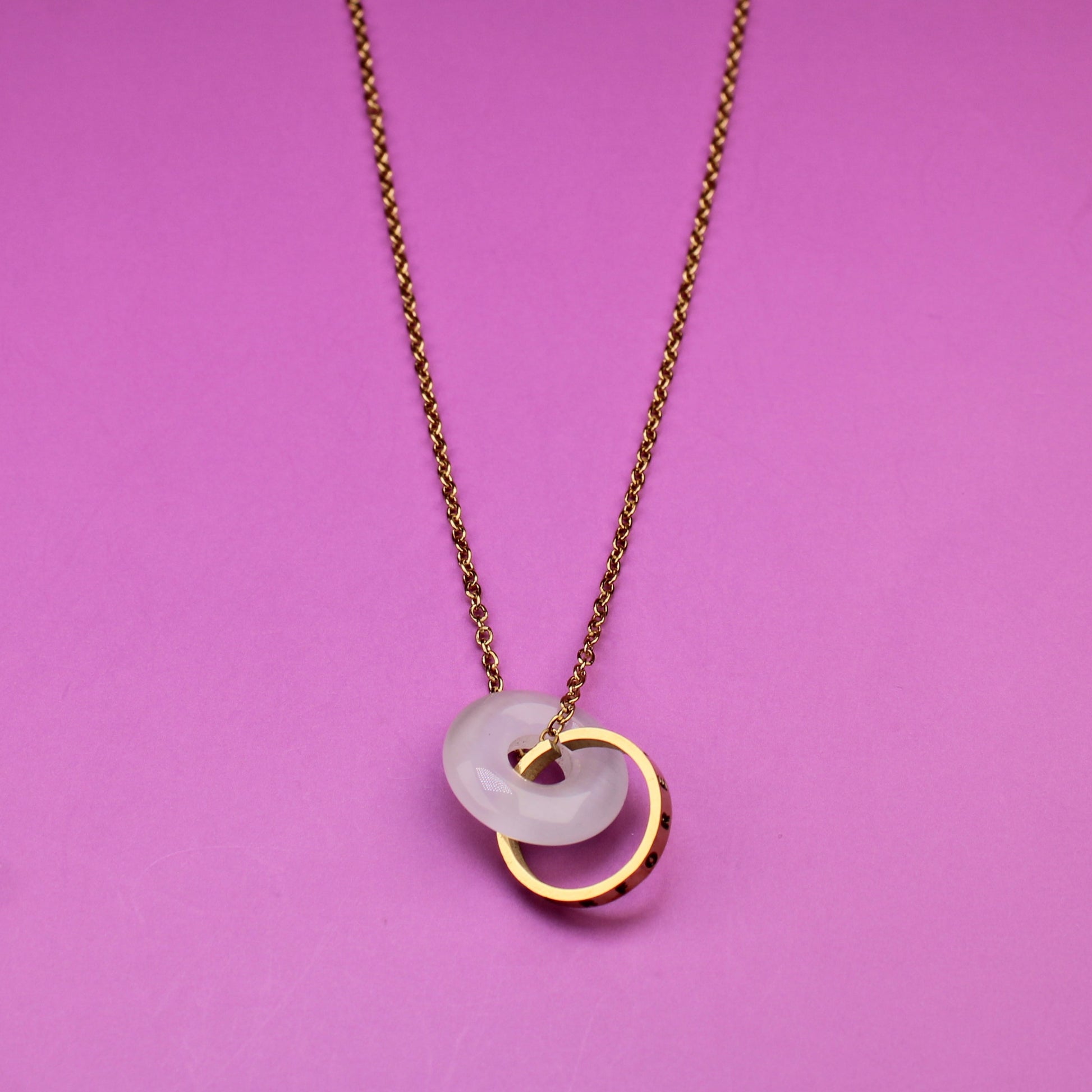 Necklace with a tag on a pink background