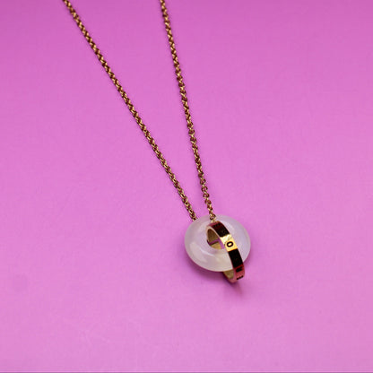 Necklace with a heart-shaped pendant on a pink background