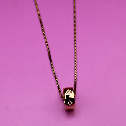 Gold necklace on a pink background