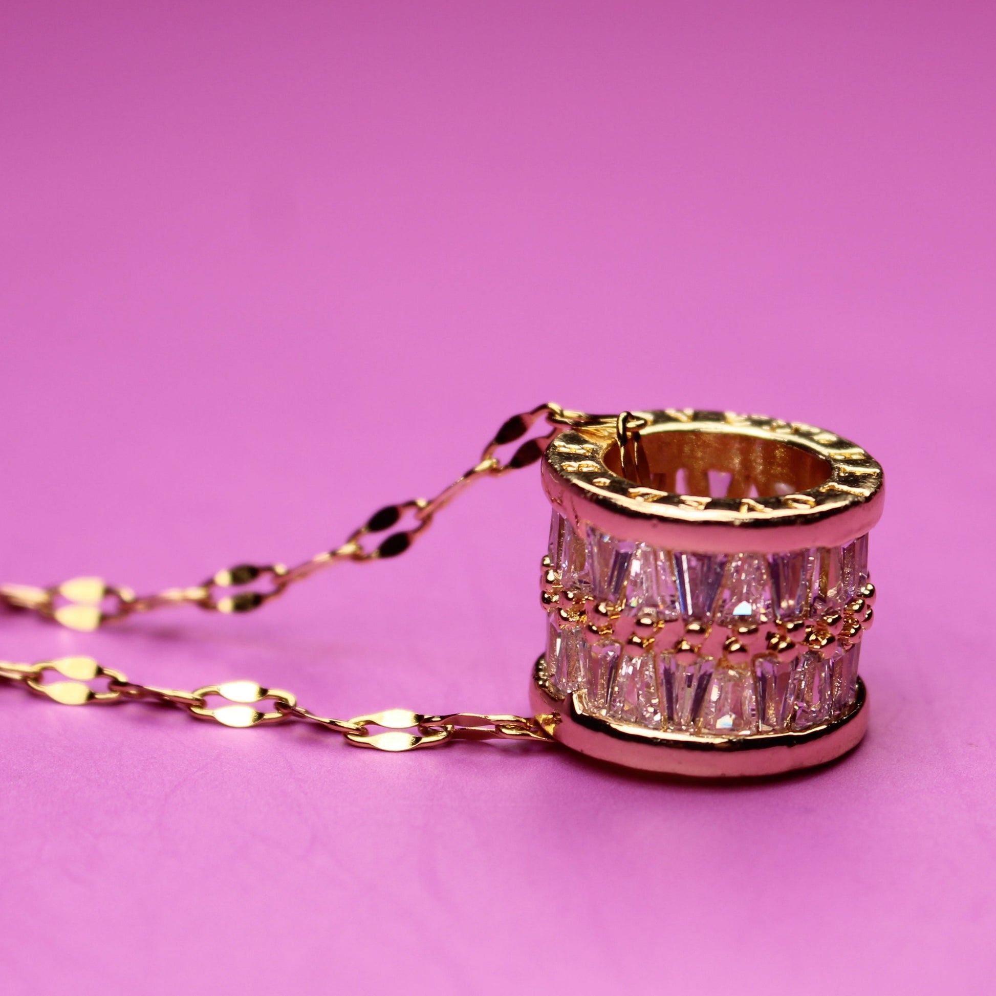 Necklace with a decorative ring pendant on a pink background