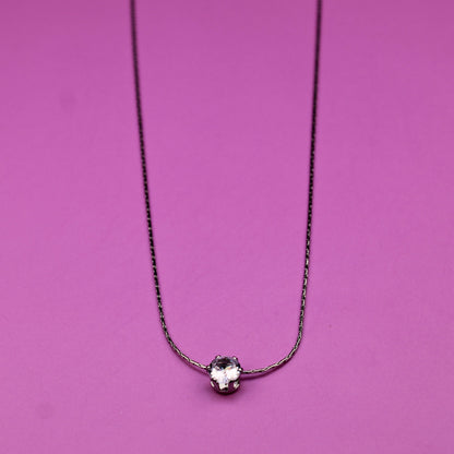 Necklace with a small round pendant on a pink background