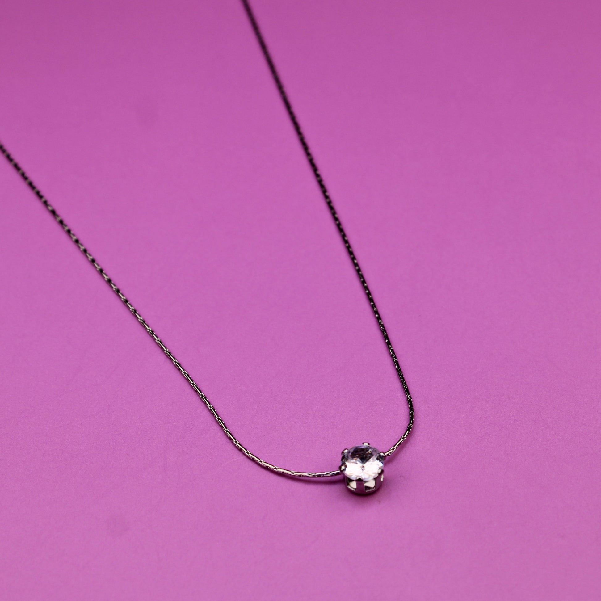 Necklace with a heart-shaped pendant on a pink background