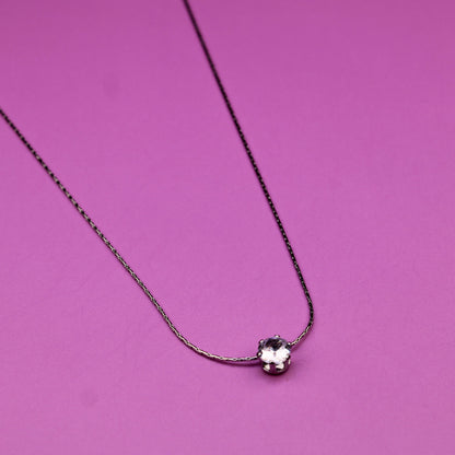 Necklace with a heart-shaped pendant on a pink background