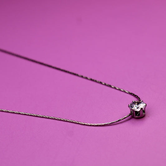 Necklace with a heart-shaped pendant on a pink background
