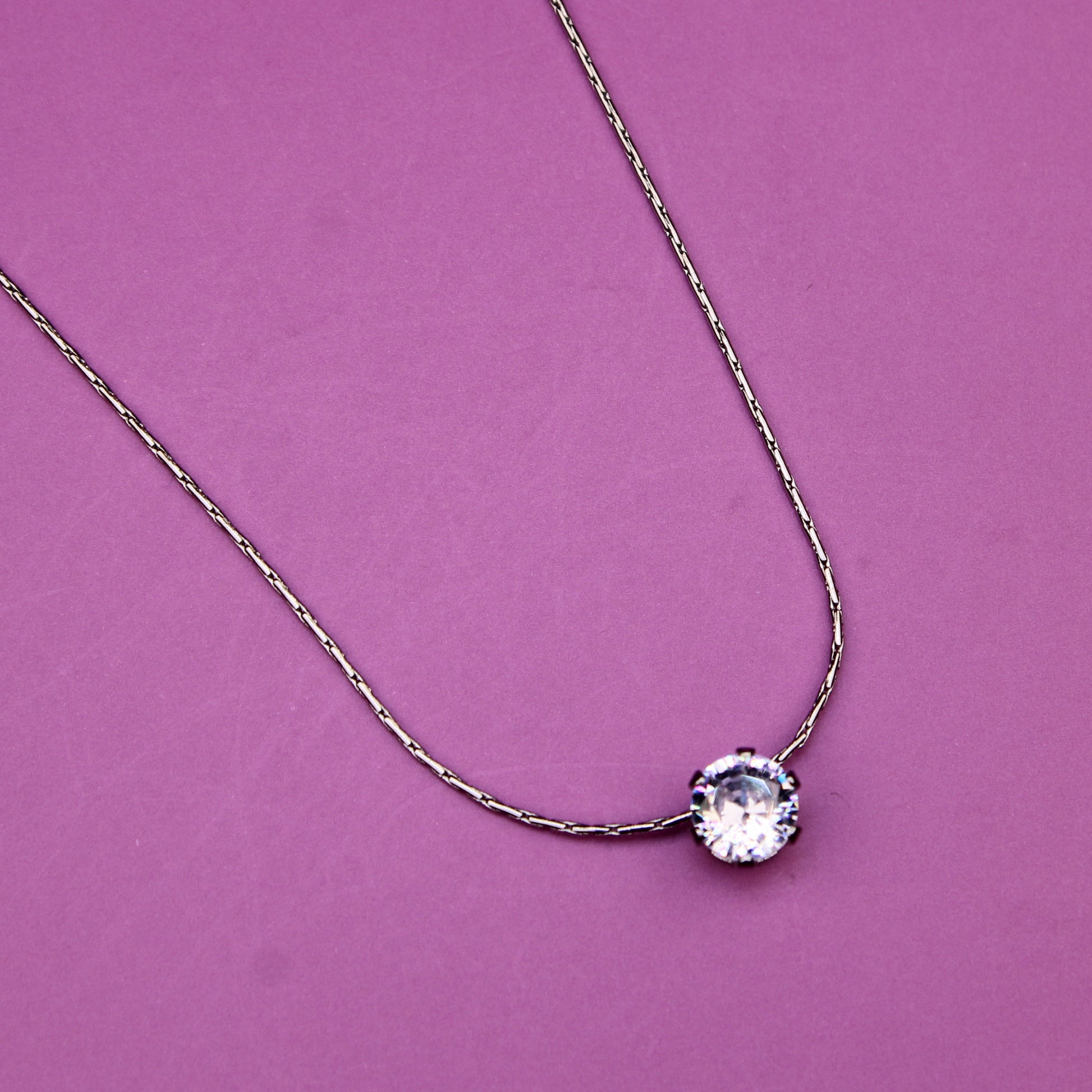 Necklace with a round pendant on a pink background