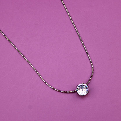 Necklace with a round pendant on a pink background