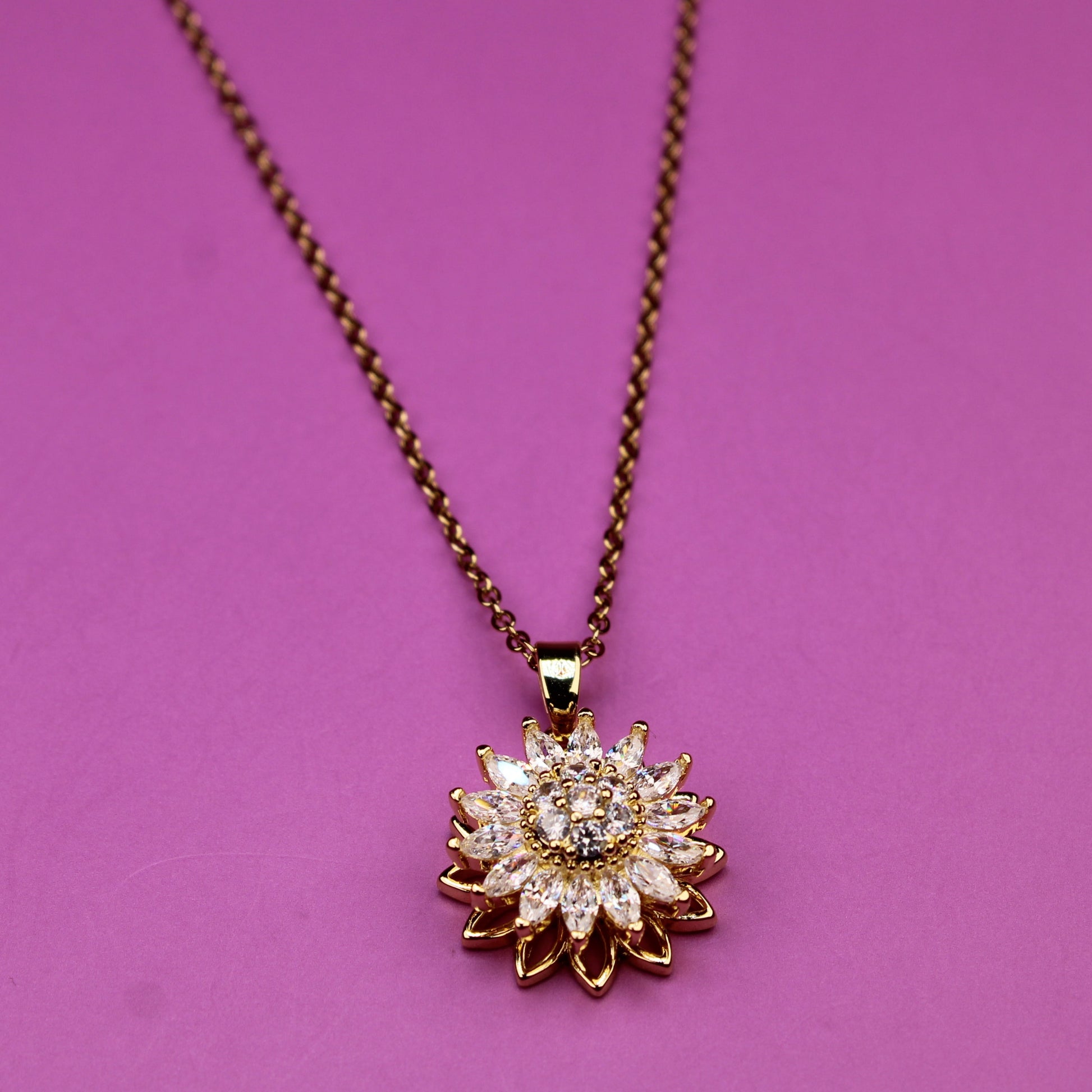 Necklace with a sunflower-shaped pendant on a pink background