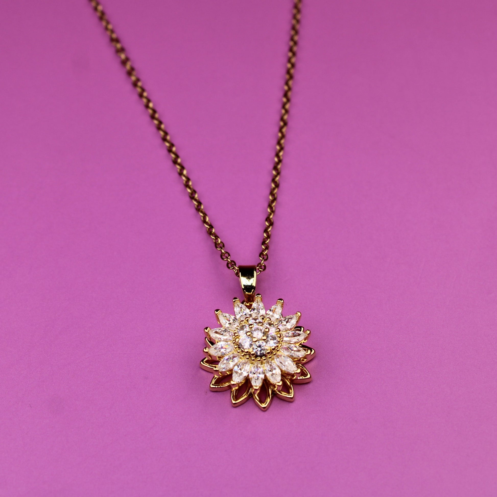 Necklace with a sunflower pendant on a pink background