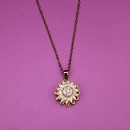 Gold sunflower pendant necklace on a purple background