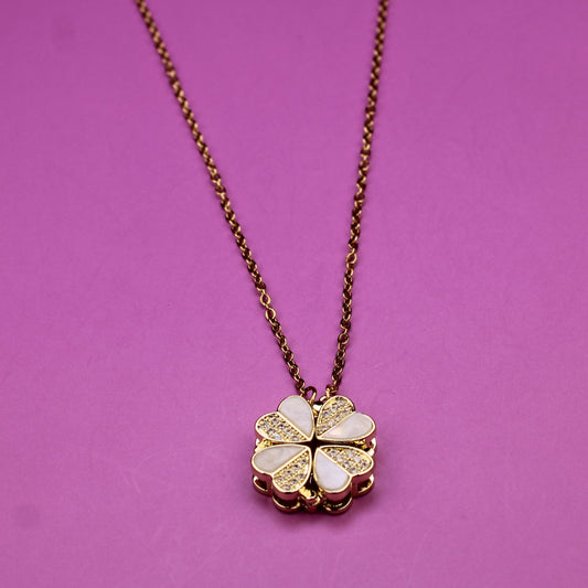 Necklace with a clover-shaped pendant on a pink background