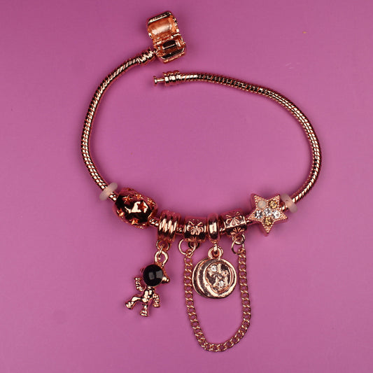 Gold bracelet with charms on a pink background