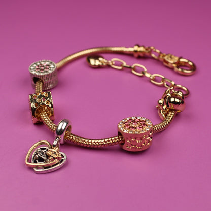 Gold bracelet with charms on a pink background