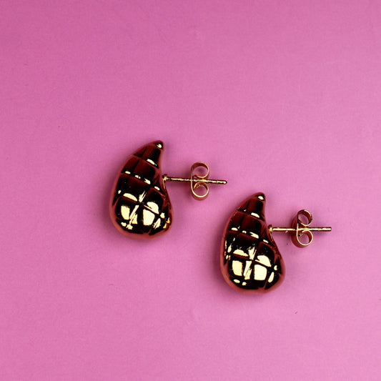 Pair of earrings on a pink background