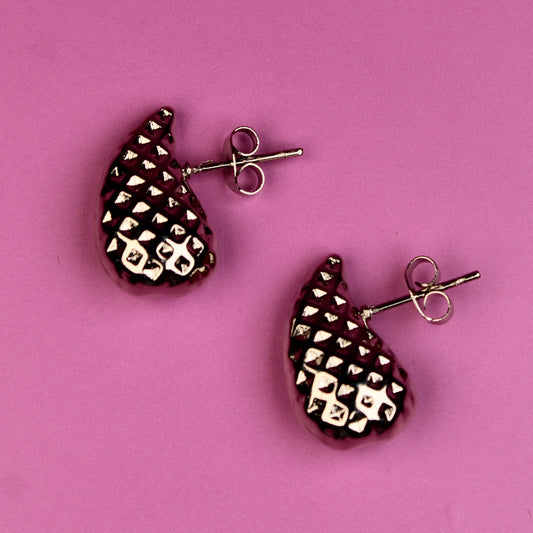 Pair of earrings on a pink background