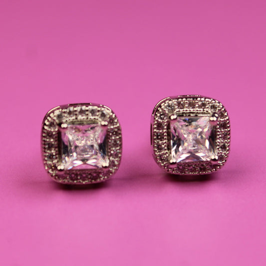 Pair of diamond earrings on a pink background
