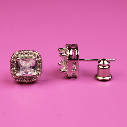 Pair of diamond earrings on a pink background