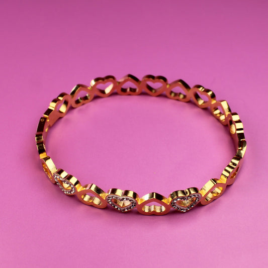 Gold bracelet on a pink background