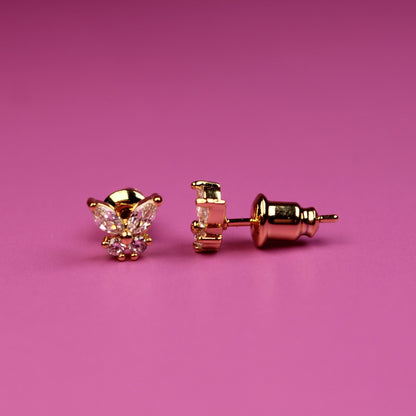 Rose gold cat-shaped earrings on a pink background