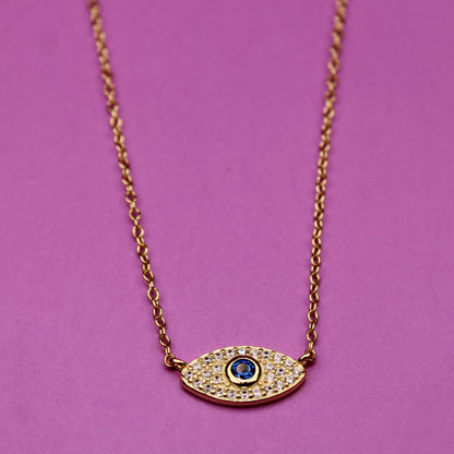 Gold necklace with an eye-shaped pendant on a purple background