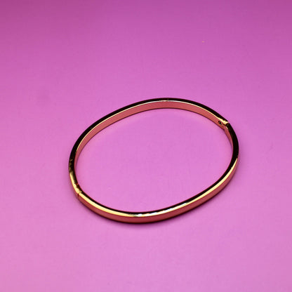 Gold bracelet on a pink background