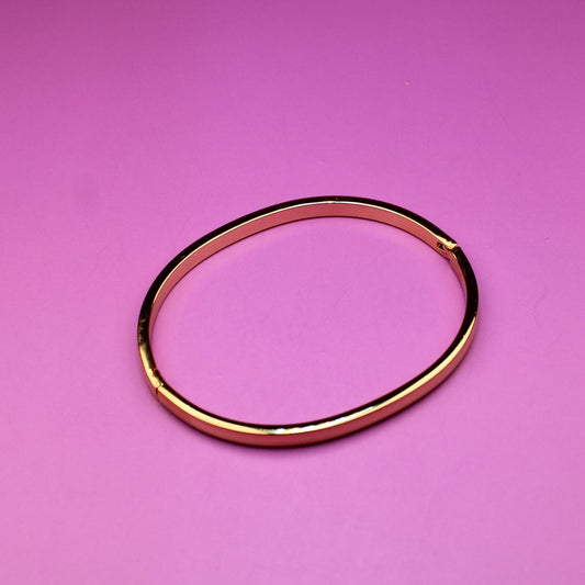 Gold bracelet on a pink background