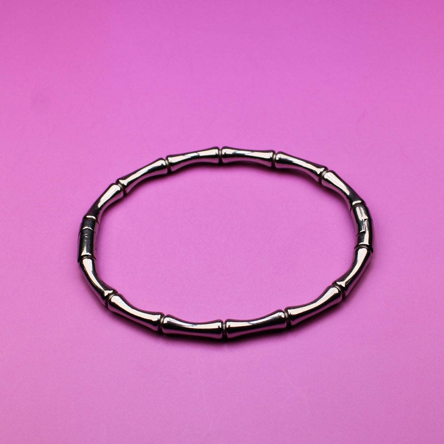 Black hair tie on a pink background