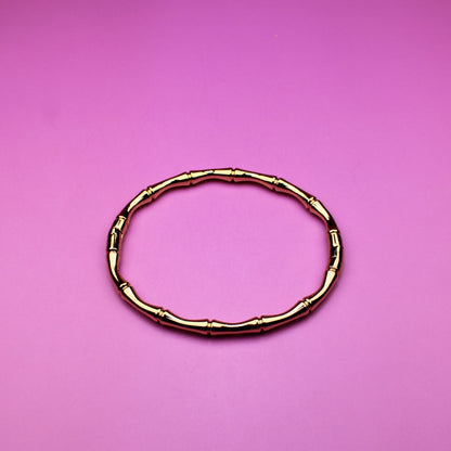 Gold bracelet on a pink background