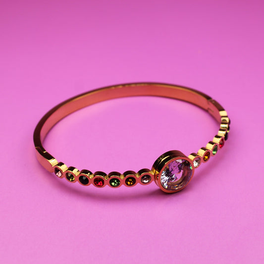 Gold ring with a pink gemstone on a pink background
