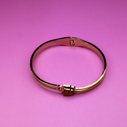 Gold bracelet on a pink background
