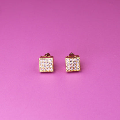 Pair of diamond-studded earrings on a pink background